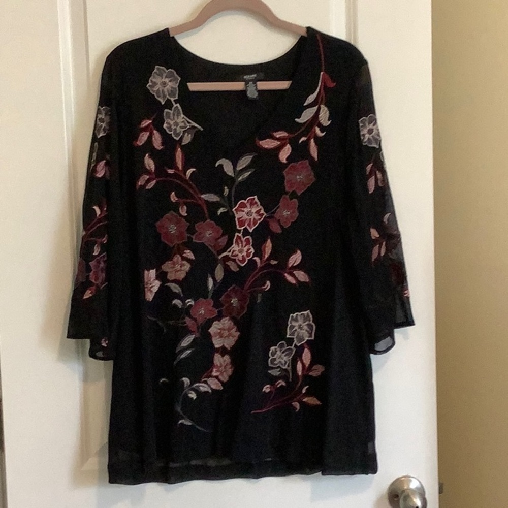 Black blouse with embroidery of flowers.